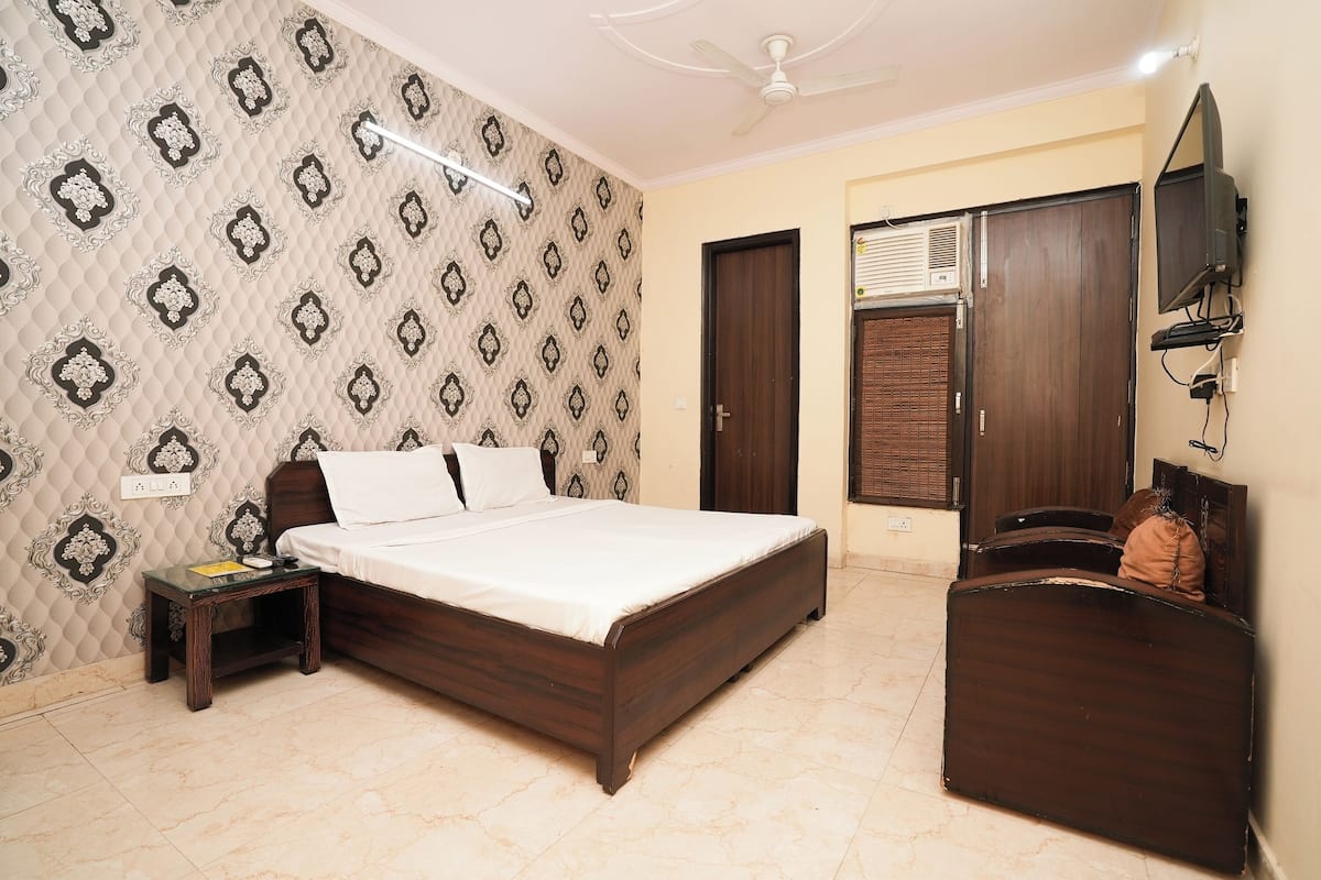 A bedroom with a bed, bedside table, wardrobe, and a ceiling fan.