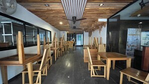 A room with wooden furniture, including tables and chairs, and a ceiling with wooden slats. - Landmark Patong Hotel (Patong)