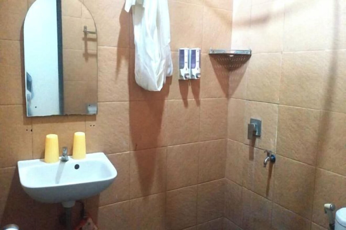 Un baño con lavabo, espejo y ducha.