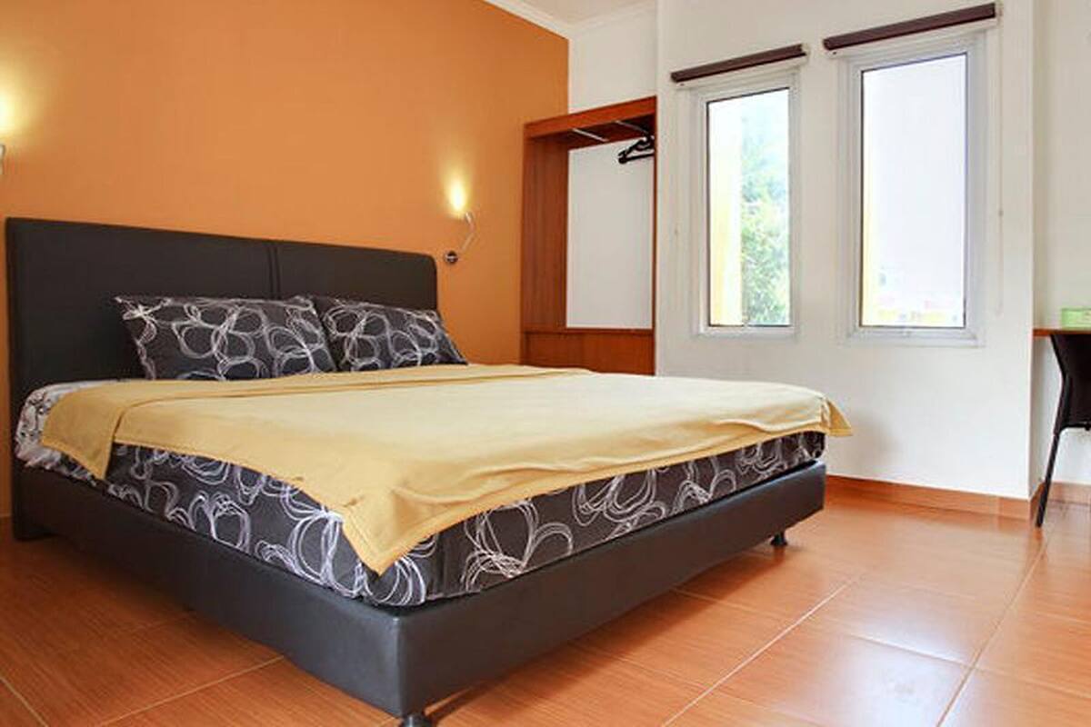A bedroom with a bed, a window, and a door.