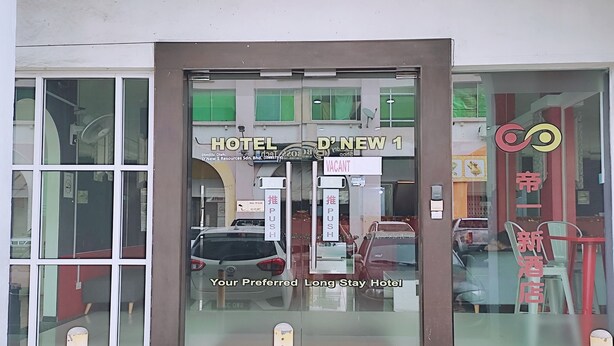 Entrada de hotel con un cartel que indica disponibilidad y un botón pulsador para entrar.