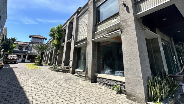 A modern building with large windows and a paved walkway. - Hotel Warta Sari (Denpasar)