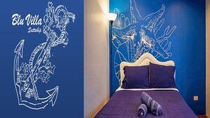 A room with a bed, a wall mural, and a lamp. - Bluvilla Sattahip (Sattahip)