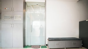Una habitación con un armario, una banca y una puerta con un cartel de 'Welcome'.