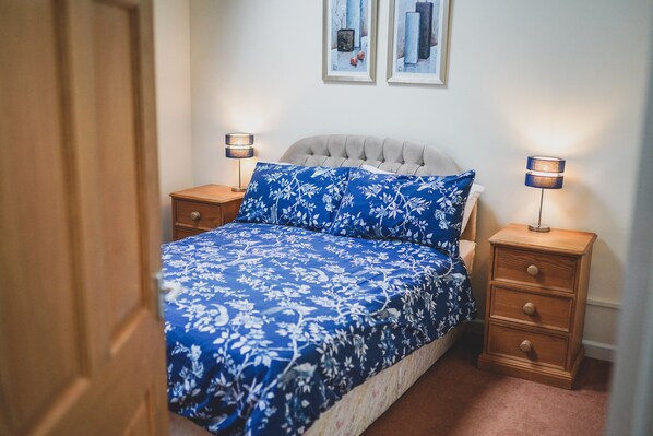 Cozy retreat with a large bed, two bedside tables, and framed artworks.