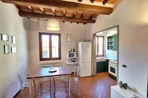 A compact kitchen with a refrigerator, microwave, and green cabinets. - Casa Mojito, apartment in the Santa Croce district (Firenze)