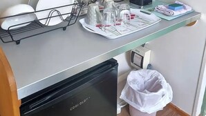 Un coin cuisine équipé d’un lave-vaisselle, d’une machine à café et d’un plateau contenant des ustensiles.
