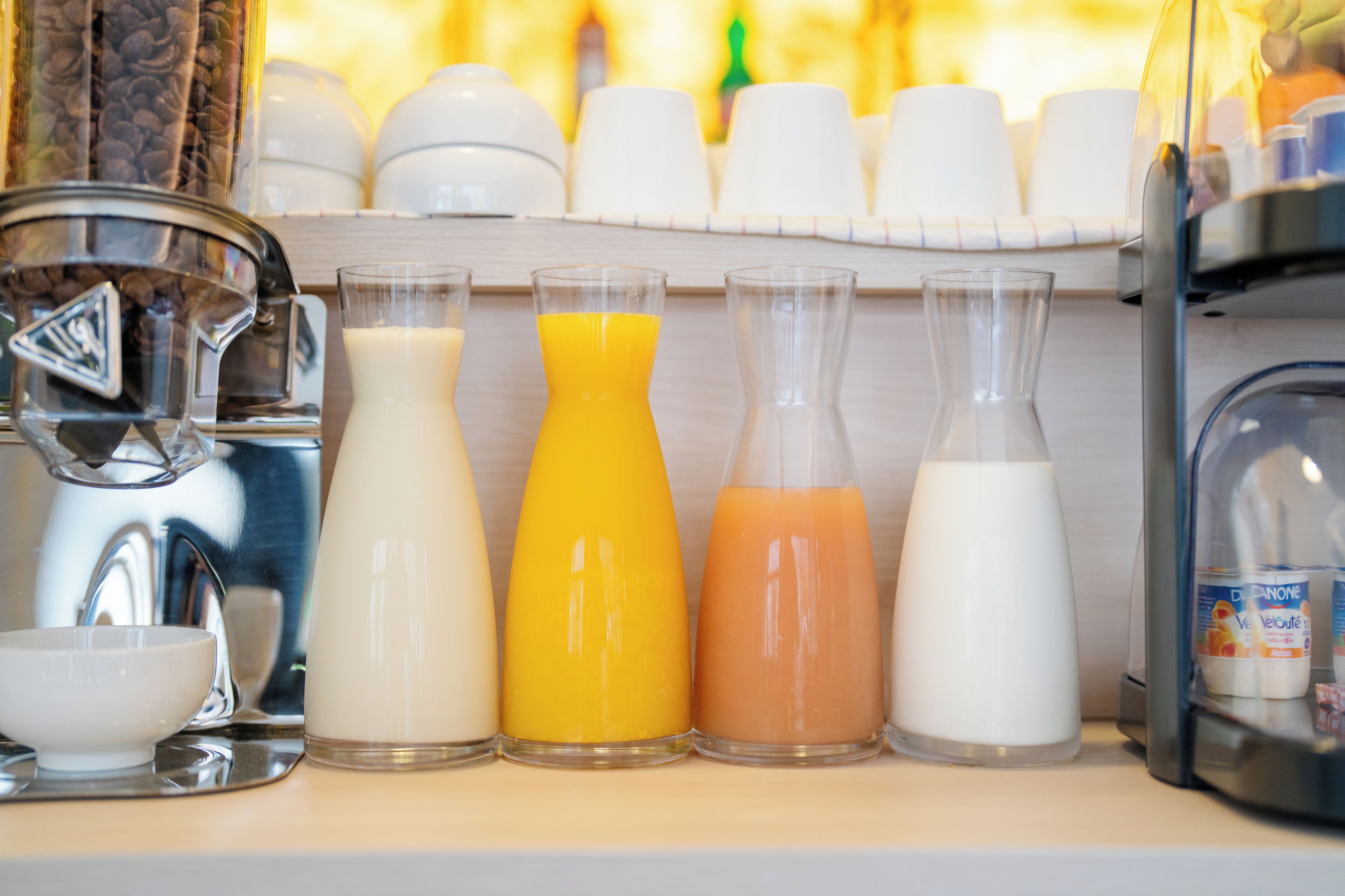 Un bar où l'on prend le petit-déjeuner, équipé de différents distributeurs de lait et de jus de fruits.
