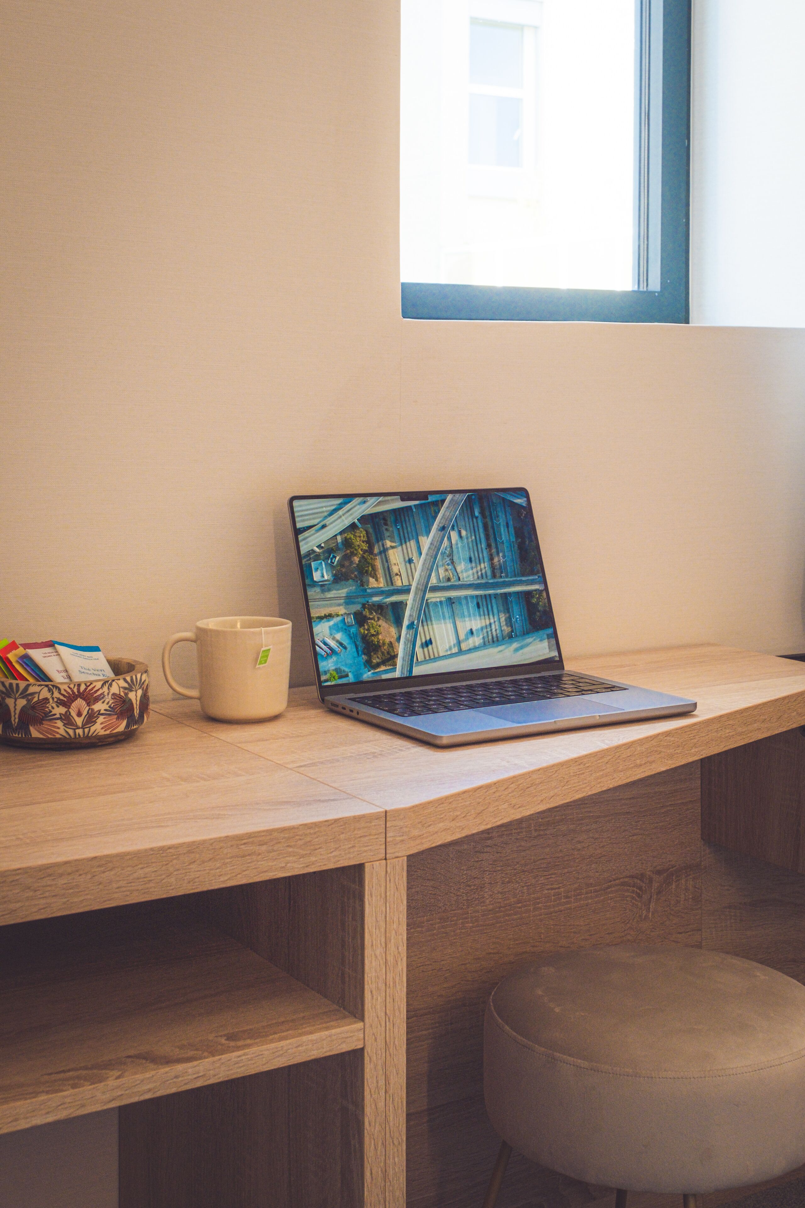 Ein Laptop auf einem Holztisch, im Hintergrund ein Fenster.