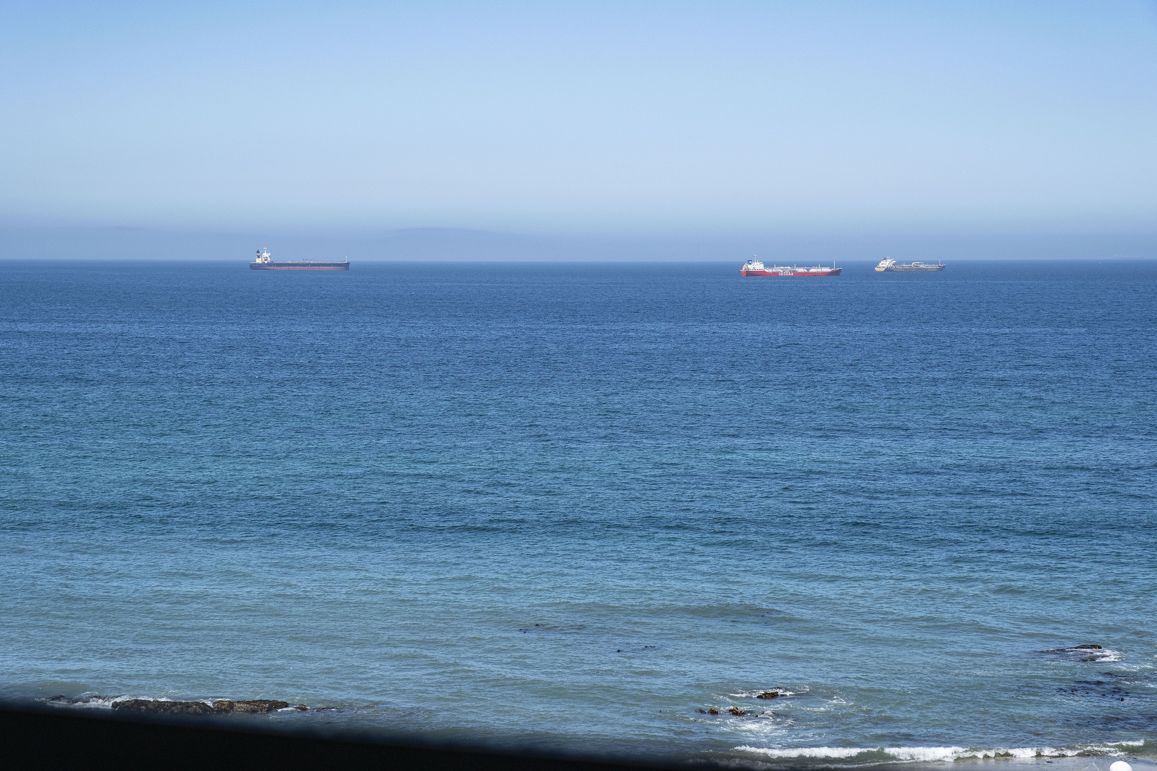 A calm sea with three ships.