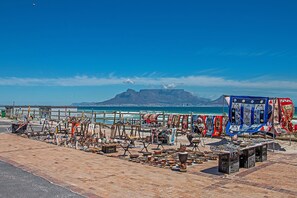 A beachside market with various stalls selling pottery and textiles.