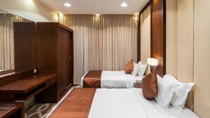 A hotel room with two beds, a desk, and a wardrobe. - Ninety Two (Unaizah)