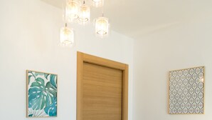 Ein Essbereich mit einem Holztisch, zwei Stühlen, einer grünen Tischmatte und einer Holztür.