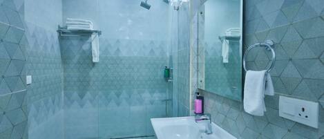 A modern bathroom with a glass-enclosed shower, a white sink, and a mirror.
