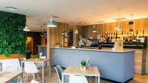 Un café moderne avec un comptoir en bois, un bar et des tables.