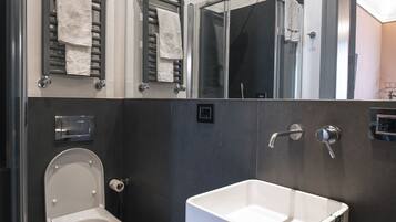 A modern bathroom with a toilet, sink, and mirrors.