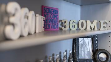 A shelf with decorative items including '360' and '360ME' signs, a welcome sign, and various bottles.