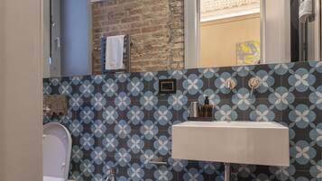 A modern bathroom with a bidet, a sink, and a mirror.