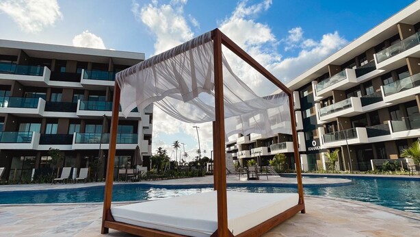 A poolside area with a wooden canopy and a mattress on the ground. - Makia Beach Resort Experience By All (Ipojuca)
