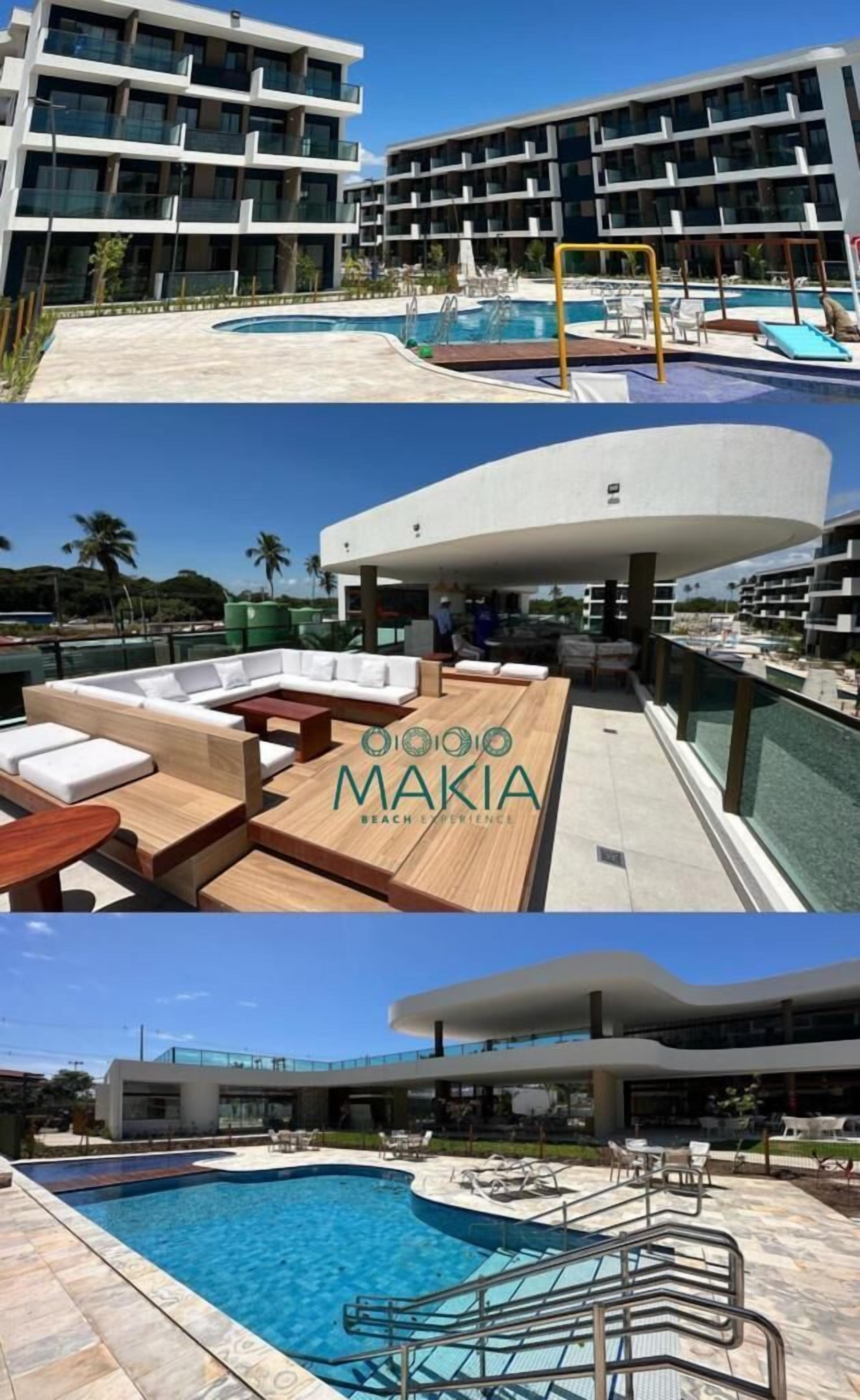 A modern hotel with a pool area, outdoor seating, and a view of the ocean.