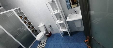A bathroom with a shower, toilet, and sink.