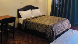 A room with a bed, a desk, and a chair.