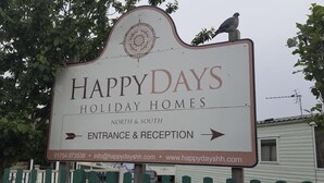 A sign for HappyDays Holiday Homes with an arrow pointing to the entrance and reception. - Beautiful 3-bed Static Caravan in Skegness (Skegness)