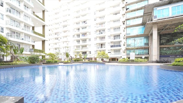 Une piscine entourée d’immeubles résidentiels à plusieurs étages, dotés de balcons.