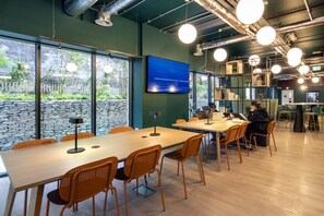 A modern conference room with large windows, a flat-screen TV, and a wooden table with chairs. - Stoneybatter Place Summer Accommodation (Dublin)