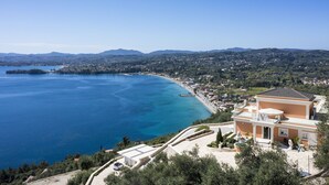 A coastal property with a view of the sea, a large house with a balcony, and a garden area. - Villa Monte Leone by Konnect with Pool, Hot Tub, Spa Room & Stunning Seaview (Corfu)