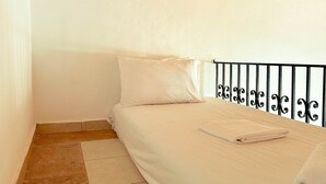 A small, single-bed room with a wooden ceiling and a metal railing. - Kali Strata 2 - Downtown (Symi)