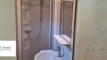 Ein Badezimmer mit Dusche, Waschbecken und Spiegel.
