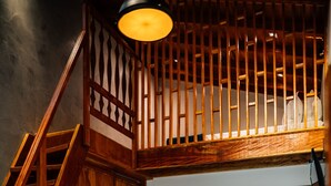 A bedroom with a bed, a wooden staircase, a bathroom with a sink and mirror, and a small desk. - Espaco Villa Verde  (Ibiuna)