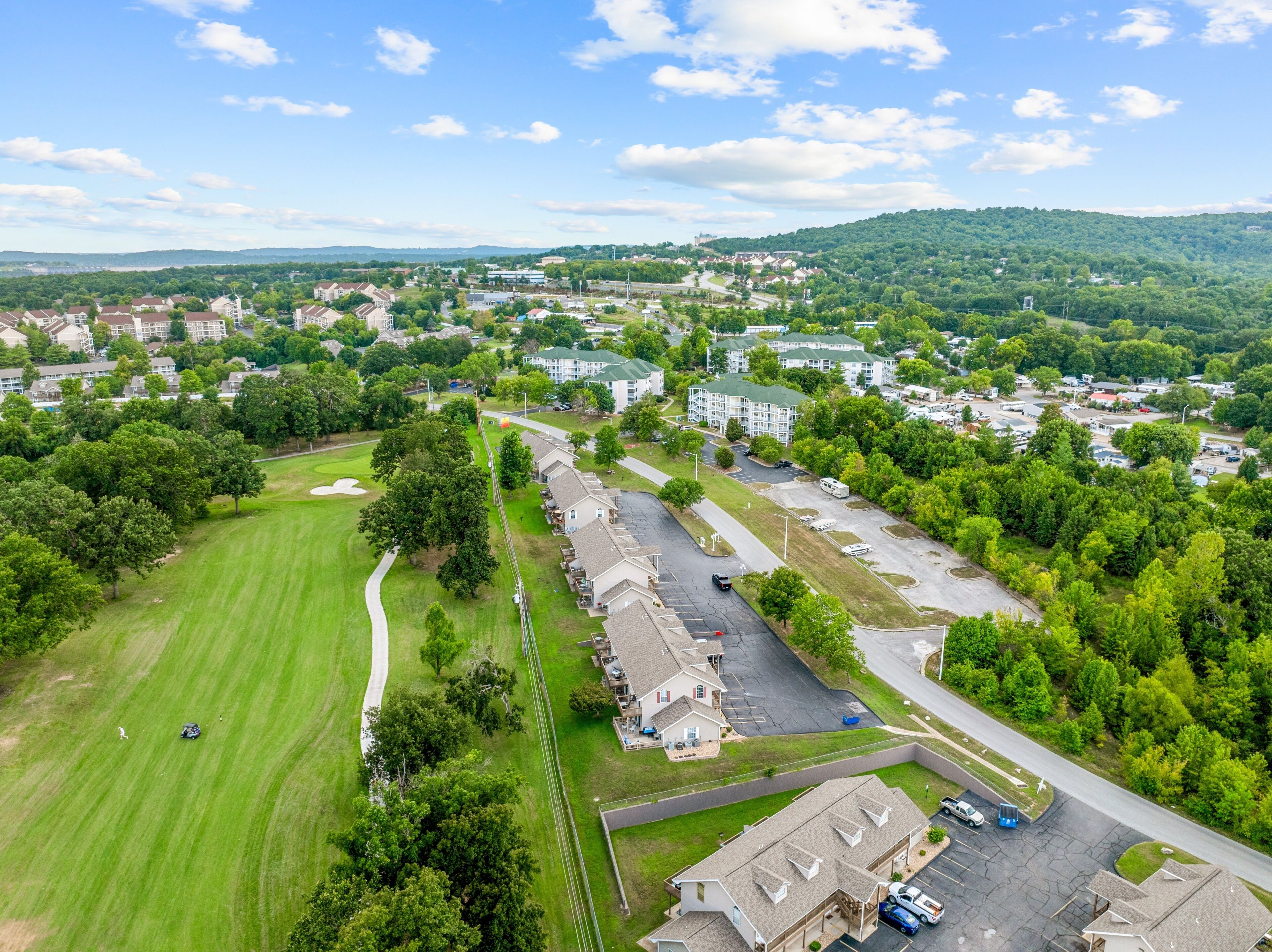 Vue aérienne d’un quartier résidentiel avec des maisons, un terrain de golf et un parking.