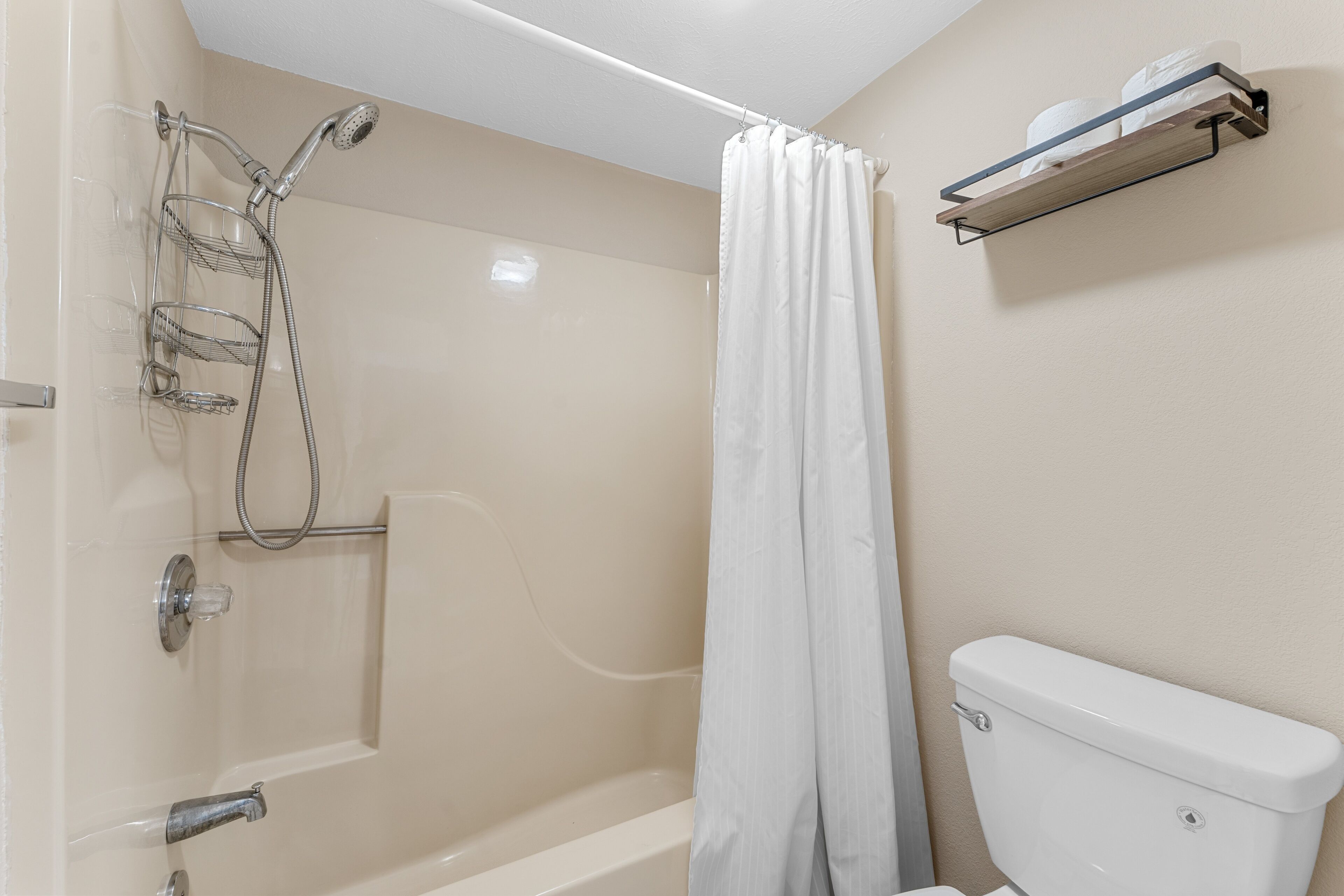 Un baño con ducha, inodoro y un perchero para toallas.