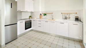 A modern kitchen with white cabinetry, a built-in oven, and a tiled backsplash. - Sun Spalato Harmony (Split)