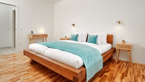 A modern bedroom with a wooden bed, white bedding, and two bedside tables with lamps. - Sun Spalato Harmony (Split)