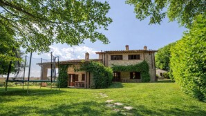 A stone house with a garden, a swing set, and a clear sky. - Scappo in Umbria, Dolce Godera (LUGNANO IN TEVERINA)