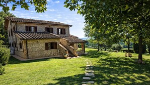 A stone house with a tiled roof, a stone staircase, and a stone pathway leading to the entrance. - Scappo in Umbria, Dolce Godera (LUGNANO IN TEVERINA)