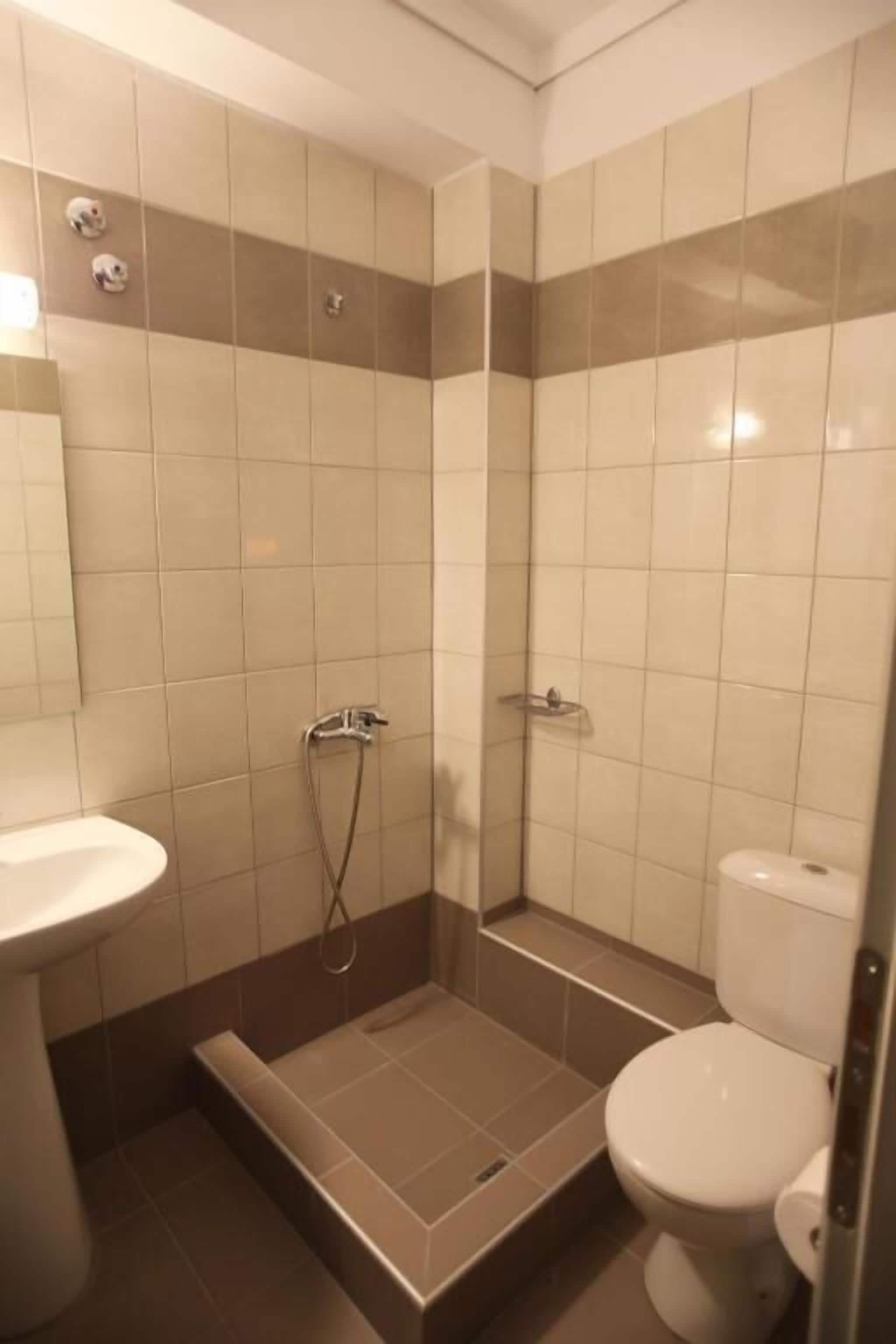Un baño con ducha, inodoro y lavabo.