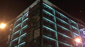 A multi-story hotel with illuminated signage and a prominent 'HOTEL' sign on the facade.