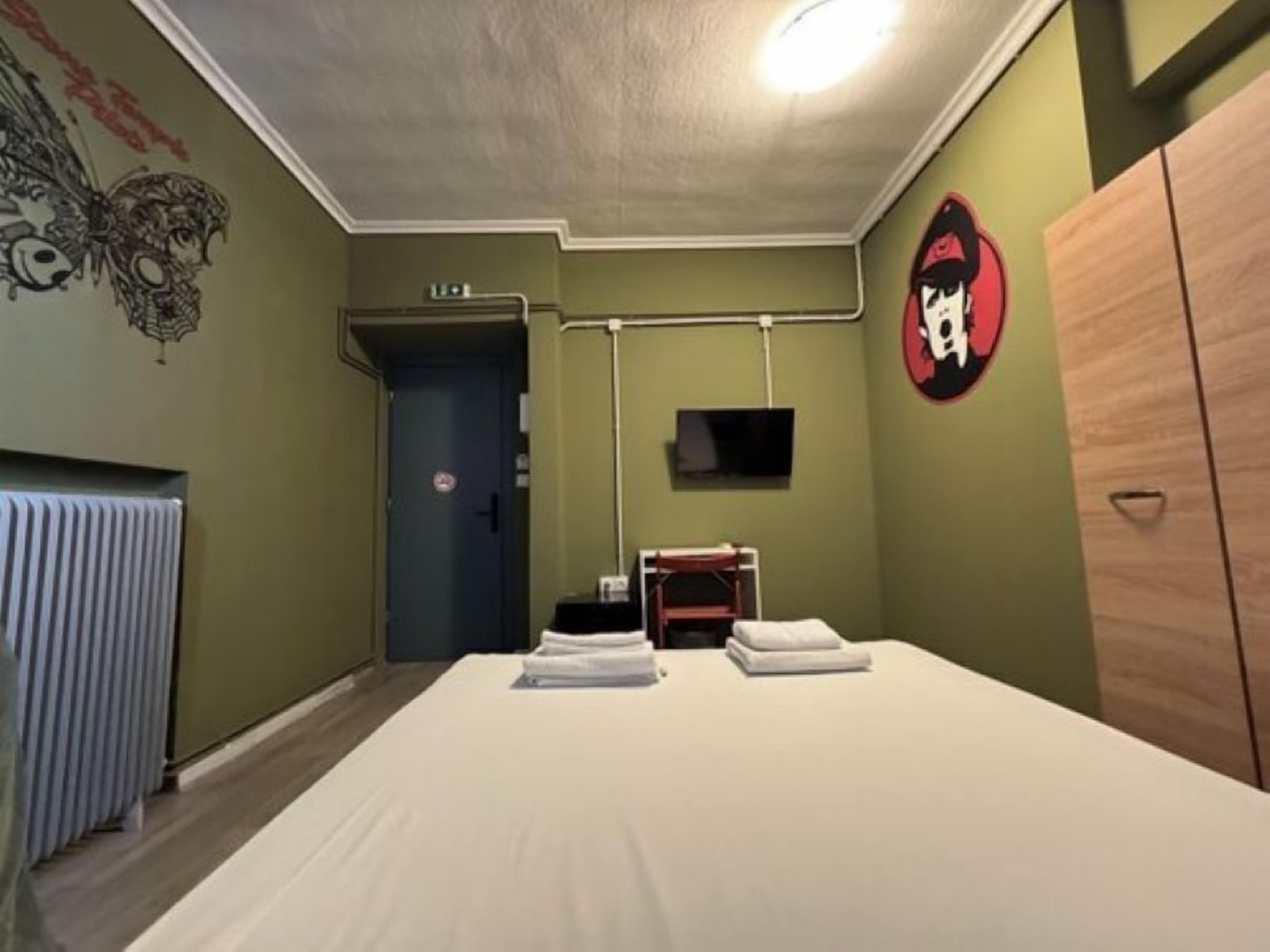 Une chambre avec un lit, un radiateur, une télévision et une armoire.