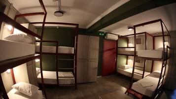 A bunk room with bunk beds arranged in a circular layout, a wardrobe, and a door.