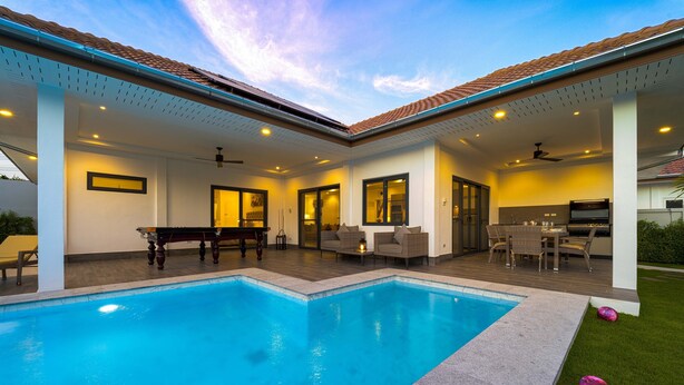 A modern outdoor pool area with a covered patio, a dining set, and a barbecue grill. - Modern 3 Bedroom Private Pool Villa -ML7 (Hua Hin)