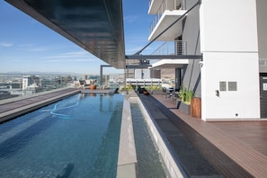 A rooftop pool with a city view, modern architecture, and outdoor seating. - 16 On Bree Unit 1713 (Cape Town)