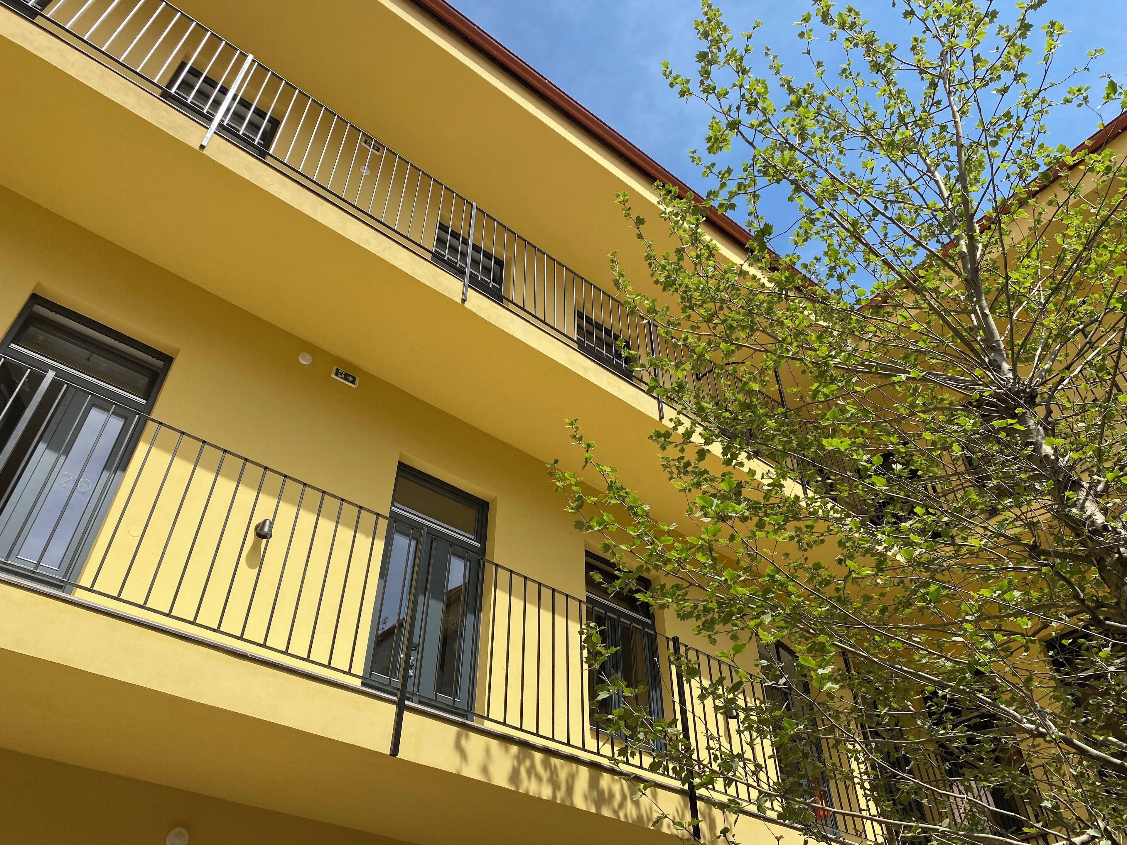 A yellow building with balconies and windows.
