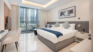 A modern hotel room with a large bed, a desk, and a chair. - Vogue | Sterling Downtown near Dubai Mall | Burj Khalifa (Dubai)