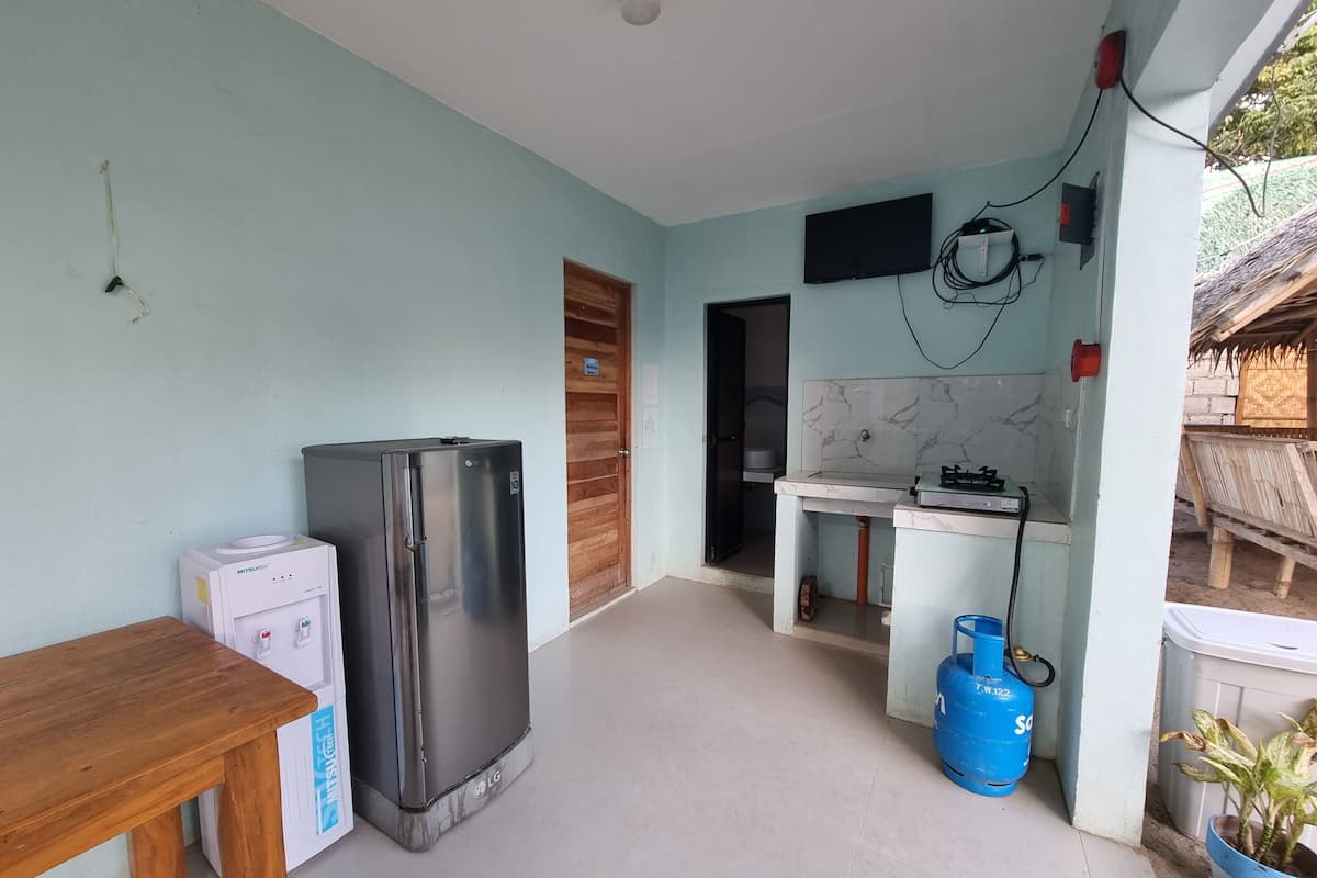 Una cocina compacta con refrigerador, pileta y estufa a gas.