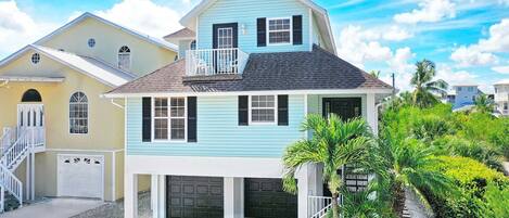 A two-story house with a balcony, a garage, and a well-maintained garden.