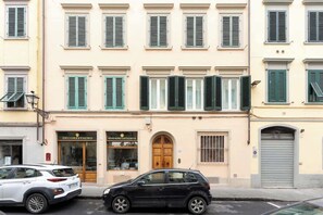 Gebäude mit verrollten Fensterläden und einem geparkten Auto davor.